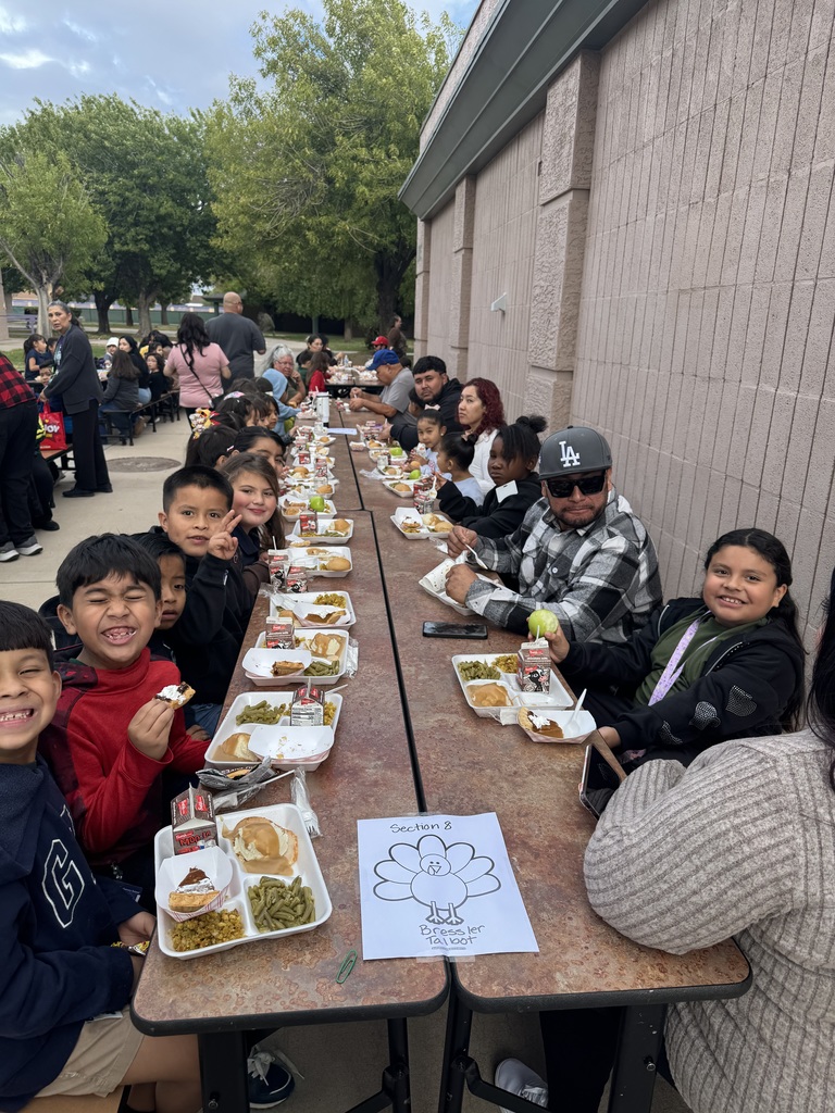 students and parents eating a thanksgiving meal outside