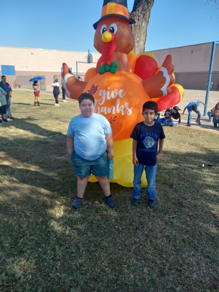 3rd grade Turkey Trot Winner posing in front of an inflated turkey.