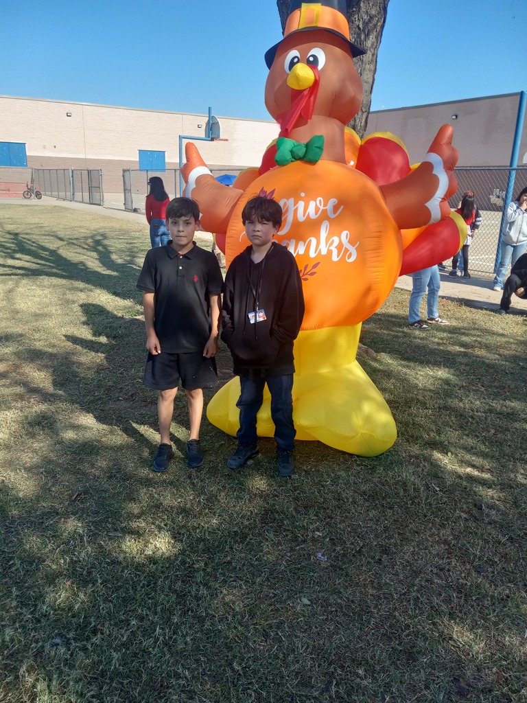 6th grade Turkey Trot Winner posing in front of an inflated turkey.