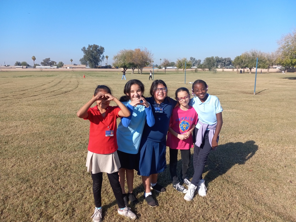 Group of girls posing for a picture in a big grass field