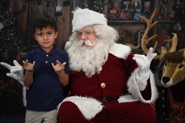student making spiderman hand gesture with Santa