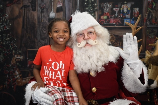 student in pajamas with Santa 