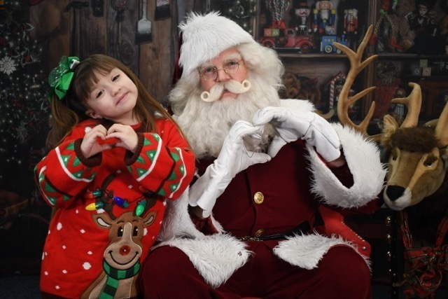 student making heart hands with Santa