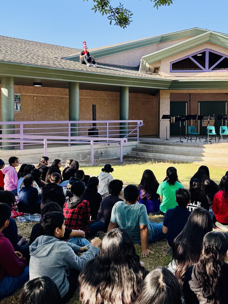 Students in the amphitheater listening to a story read by principal sitting on the roof dressed as the Cat in the Hat