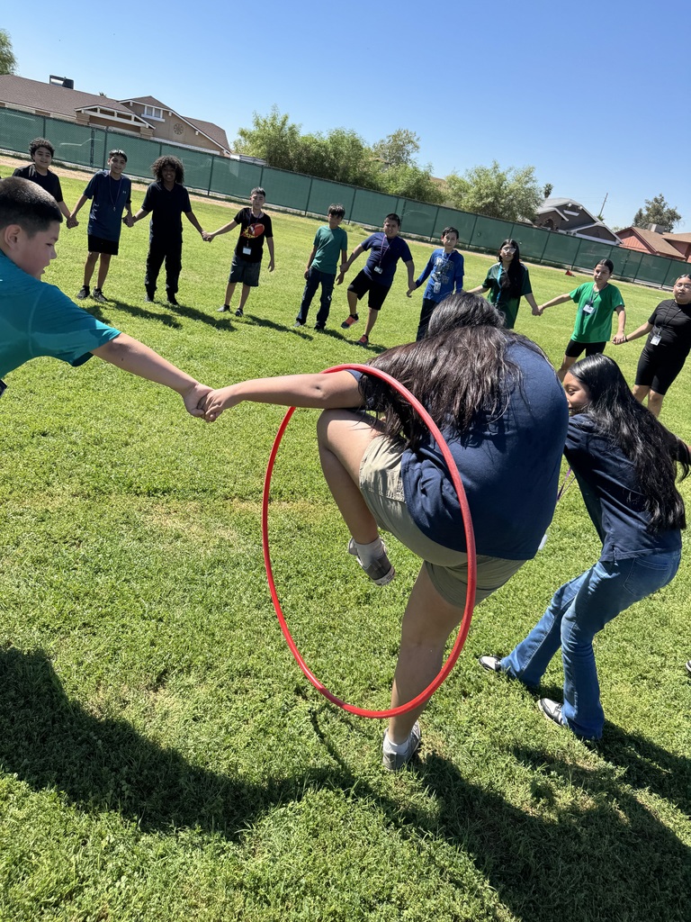 students passing through hula hoop while hands are joined
