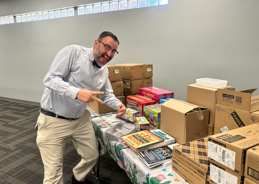 Man smiling and posing for the camera in front of a table with boxes