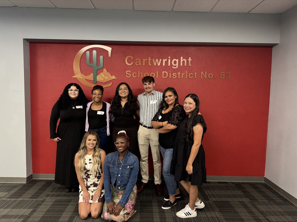 Group of people posing for the camera in front of the Cartwright Logo