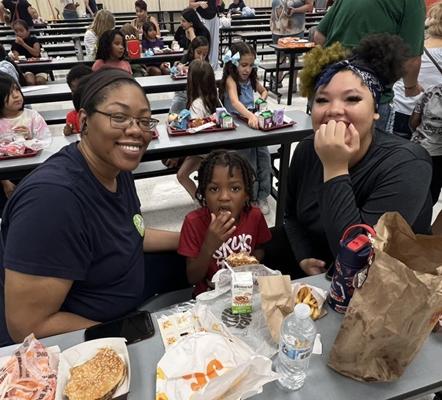 Student eating lunch with their grandparents.