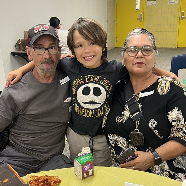 Student eating lunch with their grandparents.