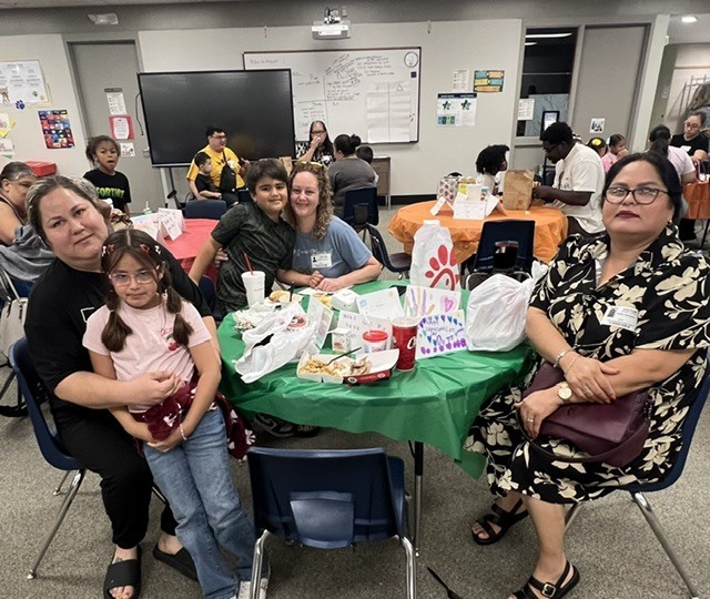 Students eating lunch with their grandparents.