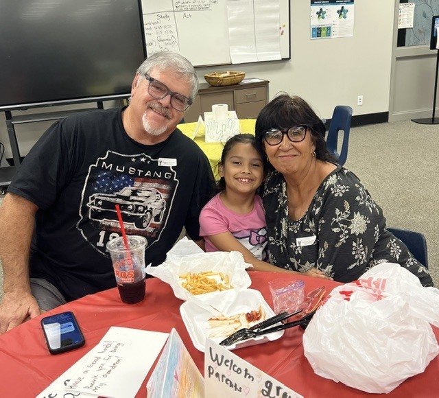 Student eating lunch with their grandparents.