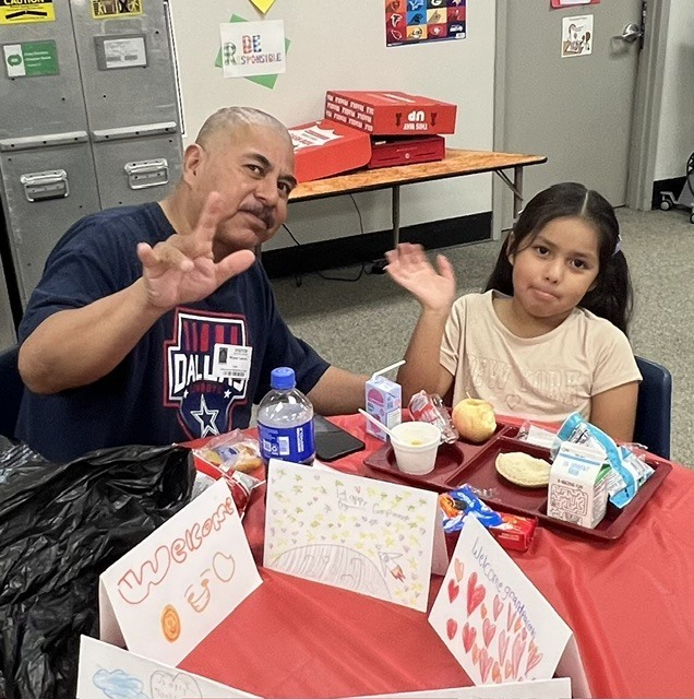 Student eating lunch with their grandparent.