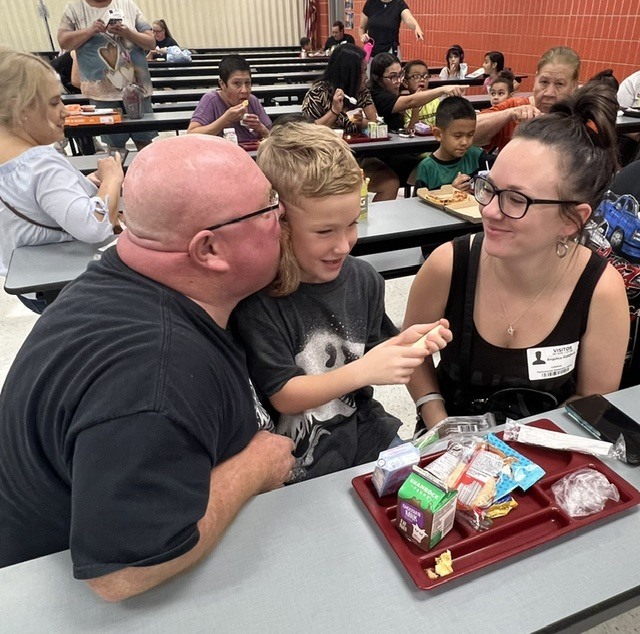 Student eating lunch with their grandparents.