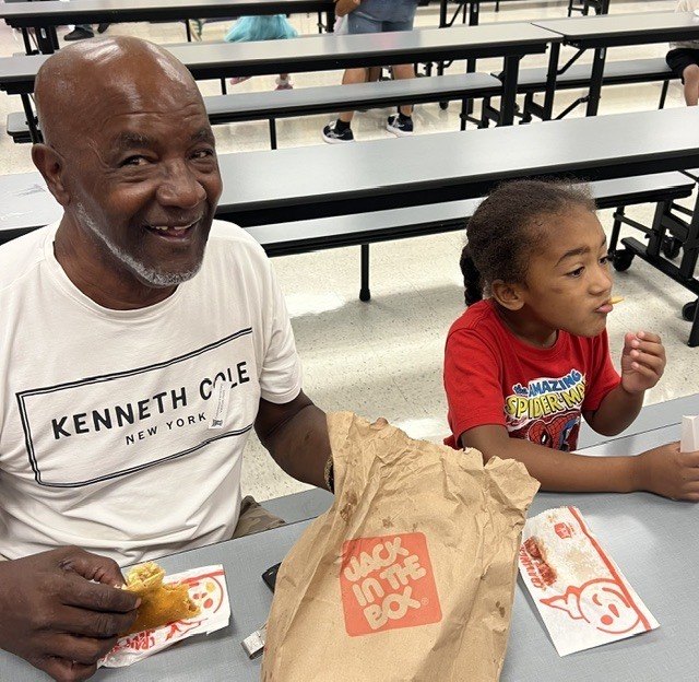 Student eating lunch with their grandparent.
