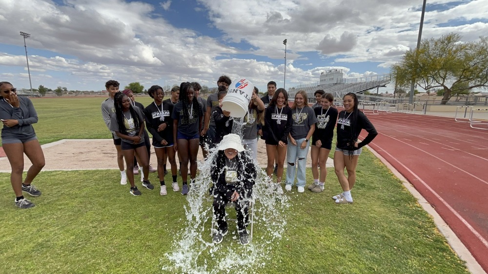 Student pouring bucket of ice water over an adult