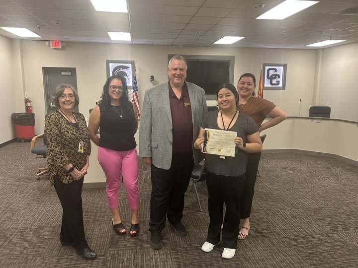 Marie Paredes-Ramirez standing with her certificate and three women and a man