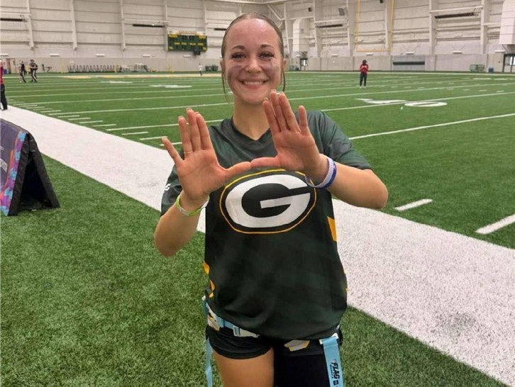Kayla Tacker smiling for photo on the field