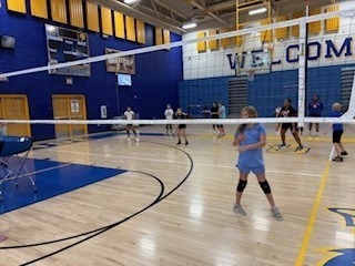 volleyball players at the net in the gym