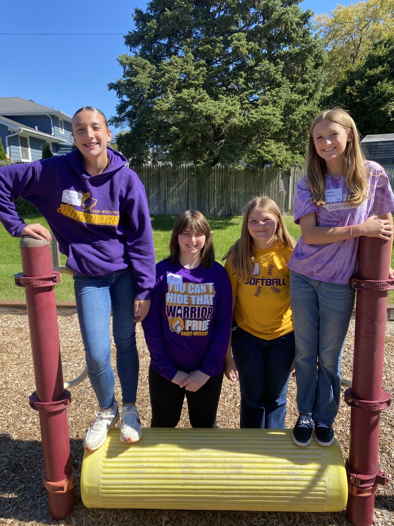 4 students on a playground posing for a photo 