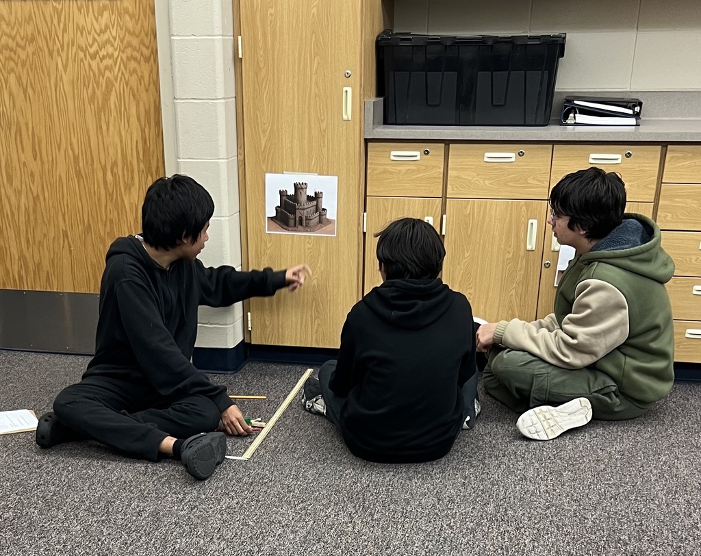 Students checking where their pumpkin struck the paper target.