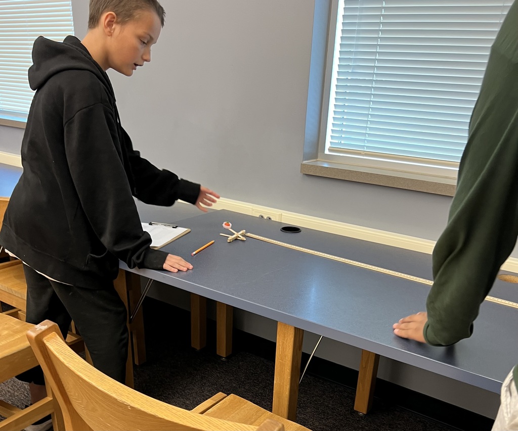 A student preparing to launch a popsicle stick catapult.