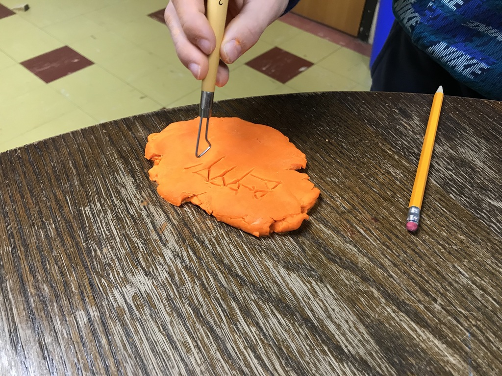 Sumerian Cuneiform - student working on clay name
