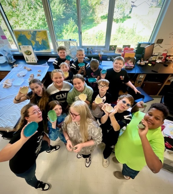 Students show clay boats.