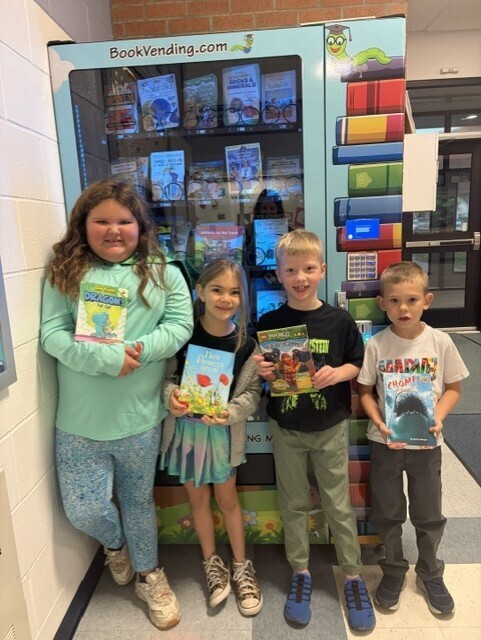4 students with books they got from the book machine