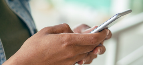 Student Technology Device Policy Reminder - hand holding smartphone