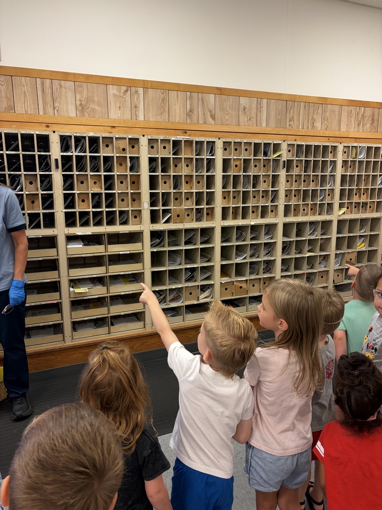Preschool students looking at inside of Post Office mailboxes