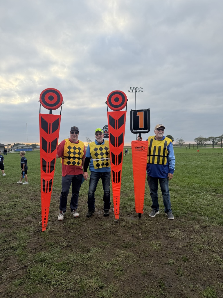 Three youth sports volunteers holding football equipment