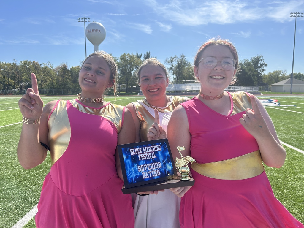 Three members of color guard showcasing Superier Rating award