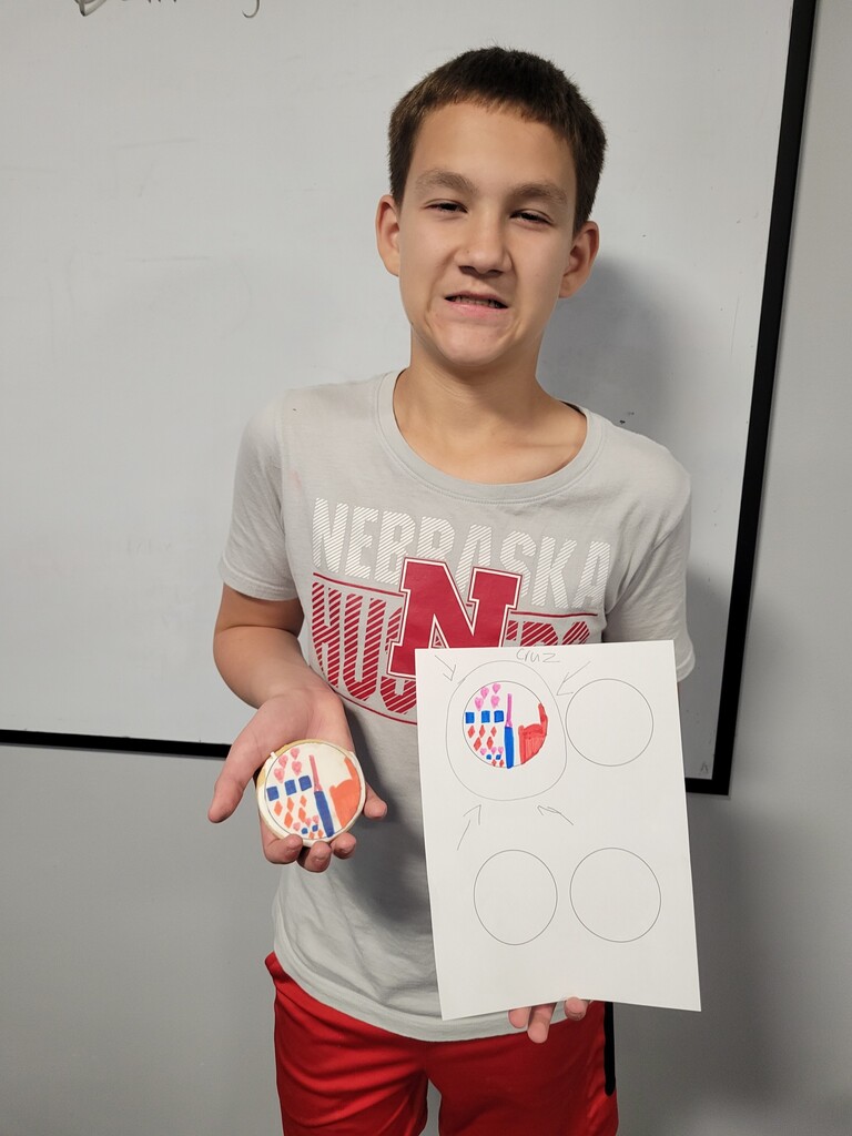 Student holding cookie with printed copy of drawing