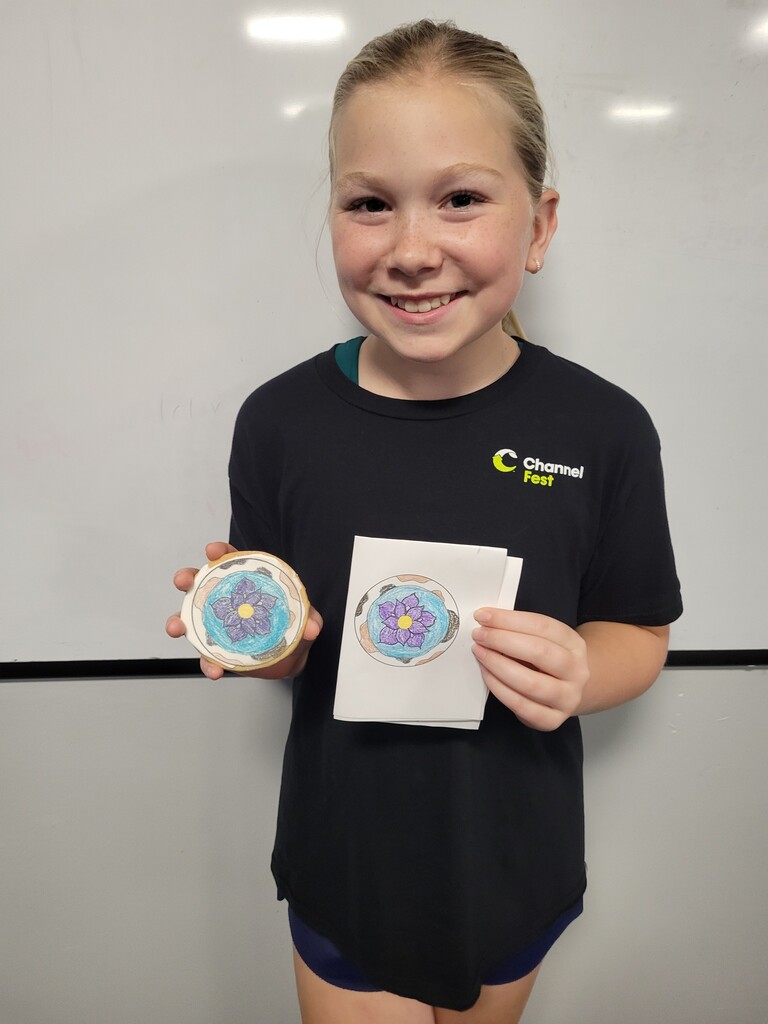 Student holding cookie with printed copy of drawing