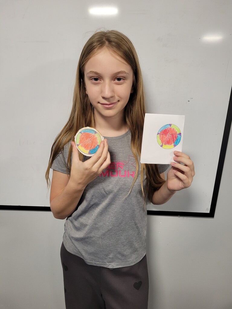 Student holding cookie with printed copy of drawing