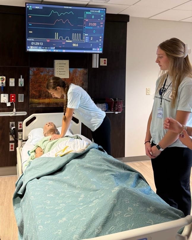 Dove Day student practicing CPR on test dummy