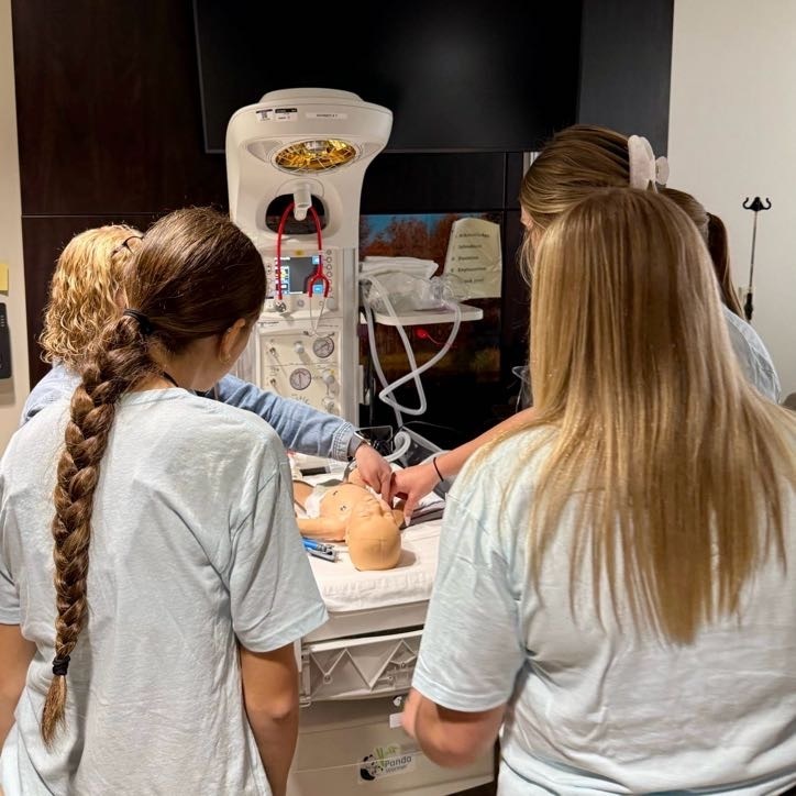Students learning about infant care using infant doll example
