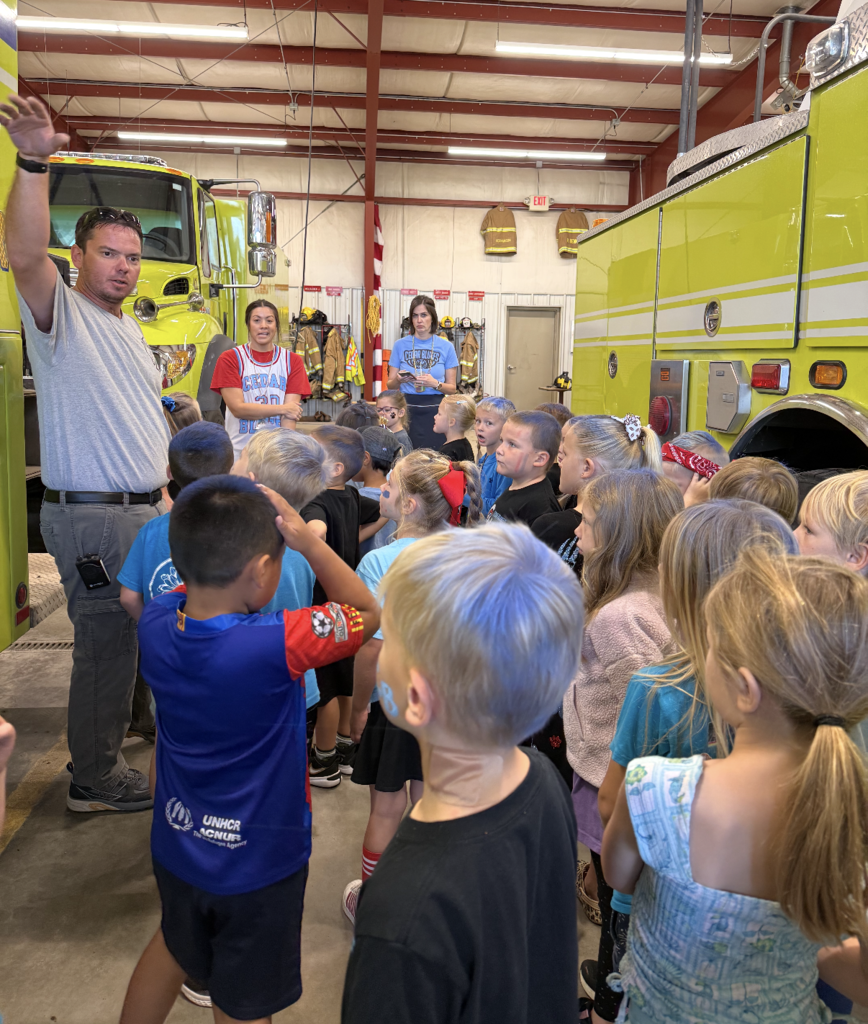 Group of kindergartners listens to firefighter explain their job