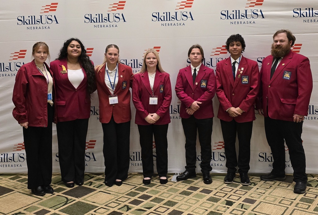 SkillsUSA students and advisors dressed in formal attire posed for group photo