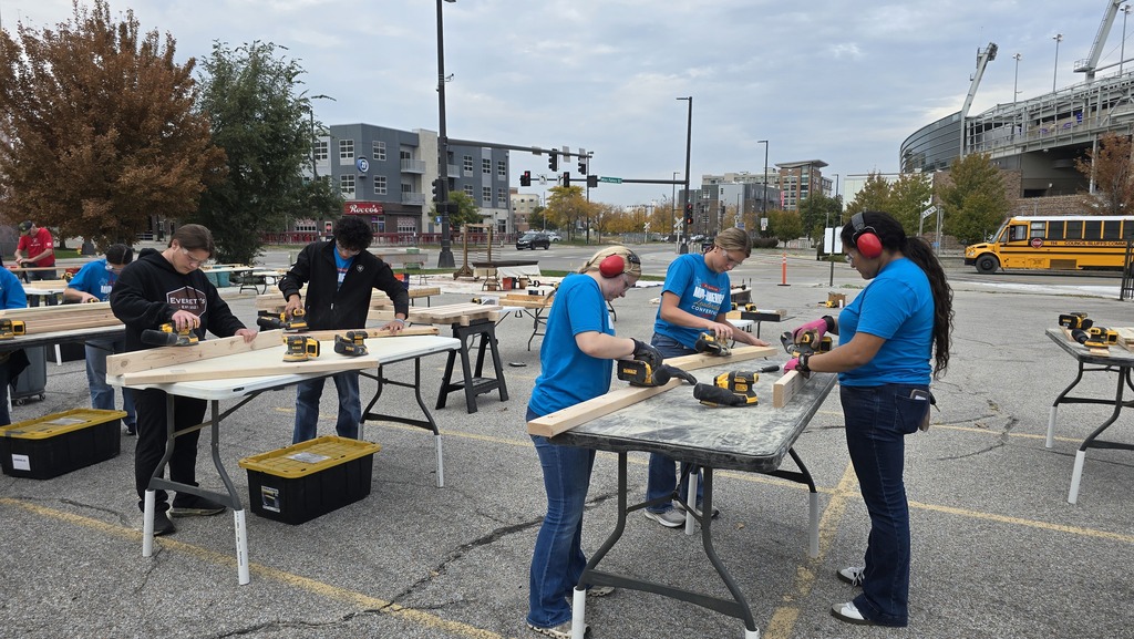 SkillsUSA students using power tools to cut and sand pieces of wood