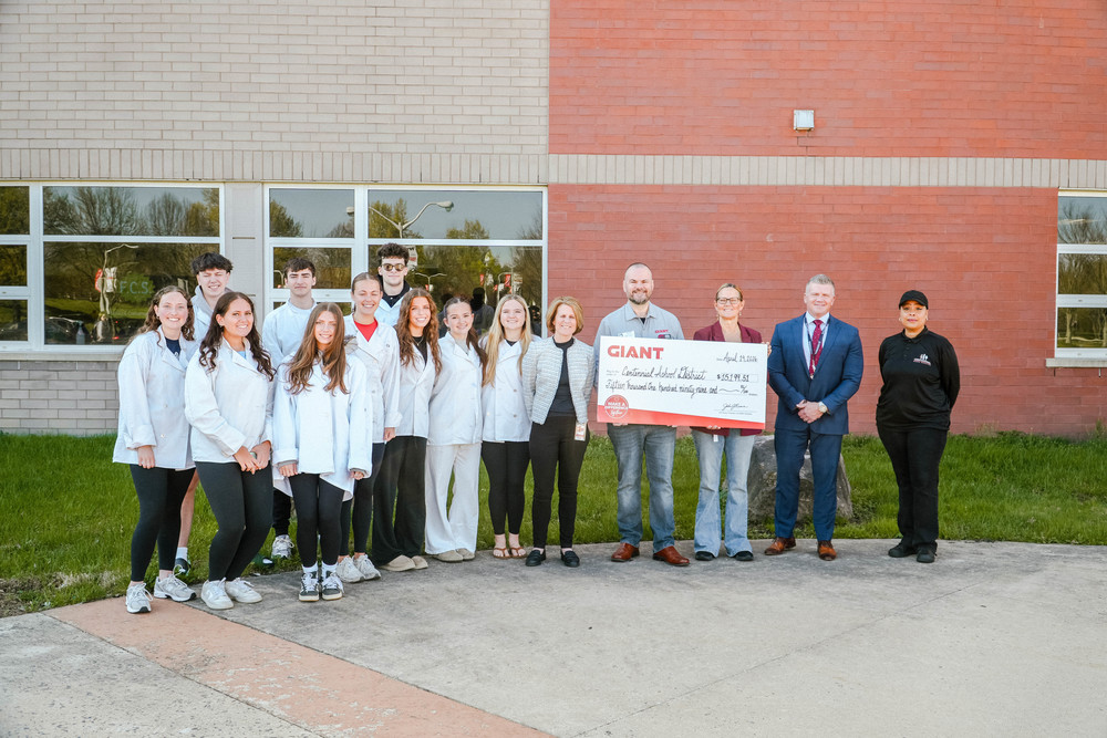 CSD staff, administration, and students holding a big check with GIANT markets officials