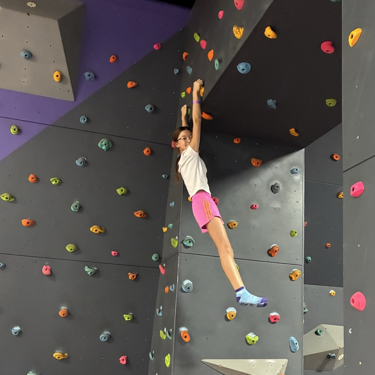 girl hanging from the climbing wall 