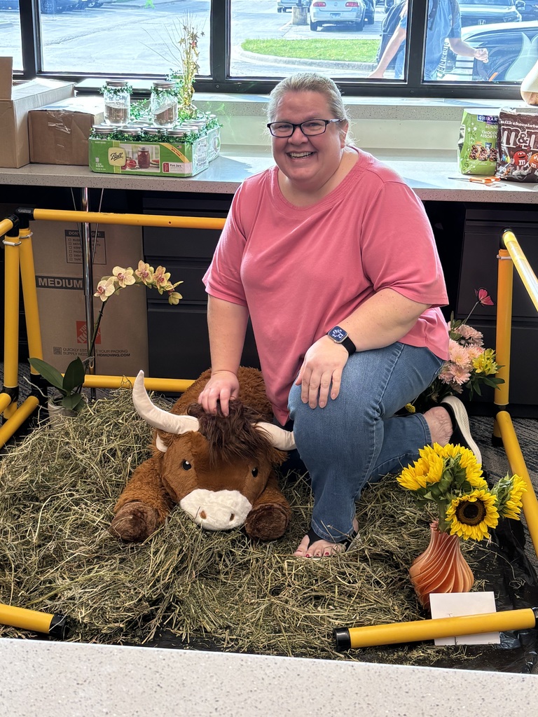 Mrs. Nawrot in stuffed bull pen with hay and flowers