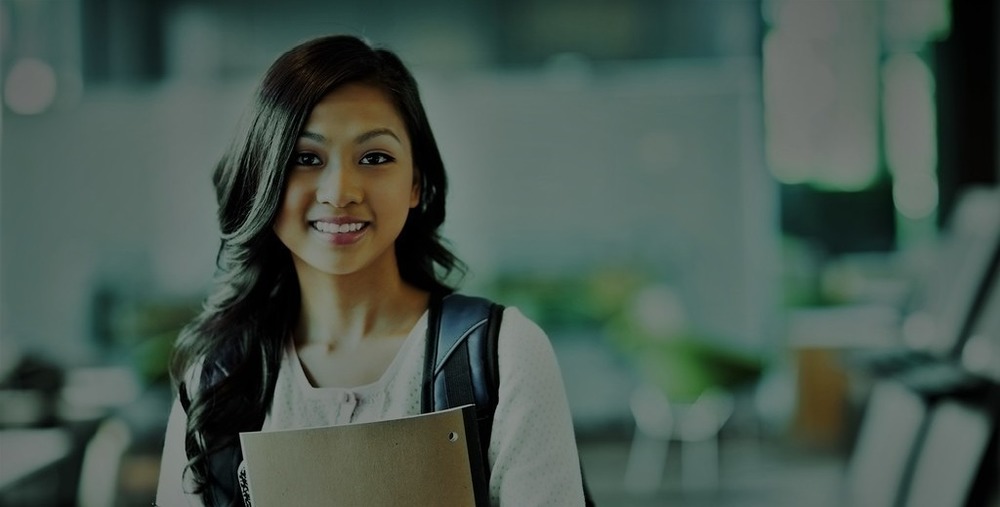 Smiling teacher with notebook and pencil