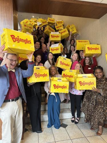 Bedenbaugh and TEachers holding Bojangle's boxes filled with books for the classroom