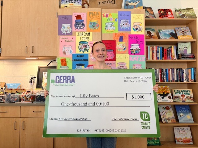 Lily holding her scholarship check.
