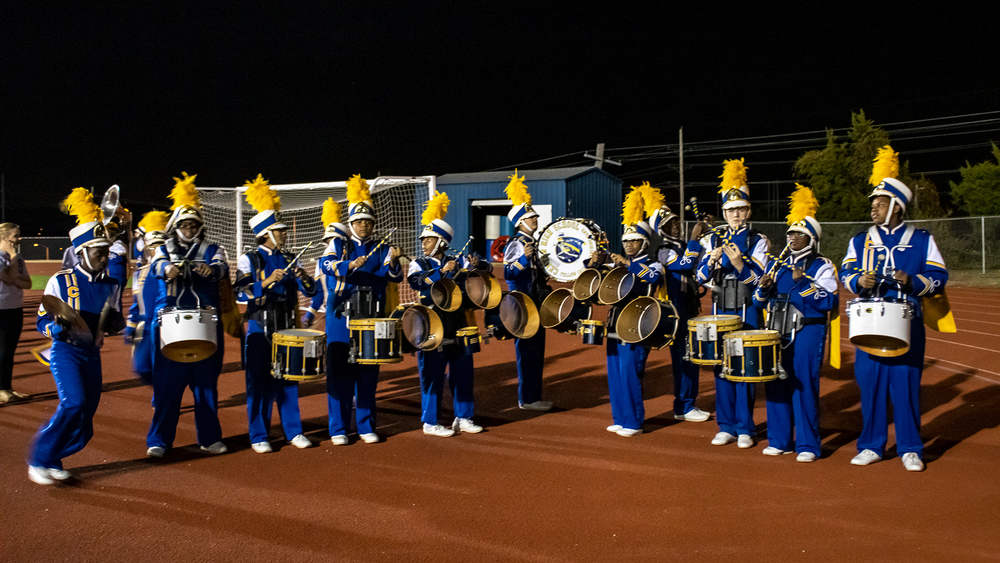 Center School District drumline stands on the CHS track in their uniforms.