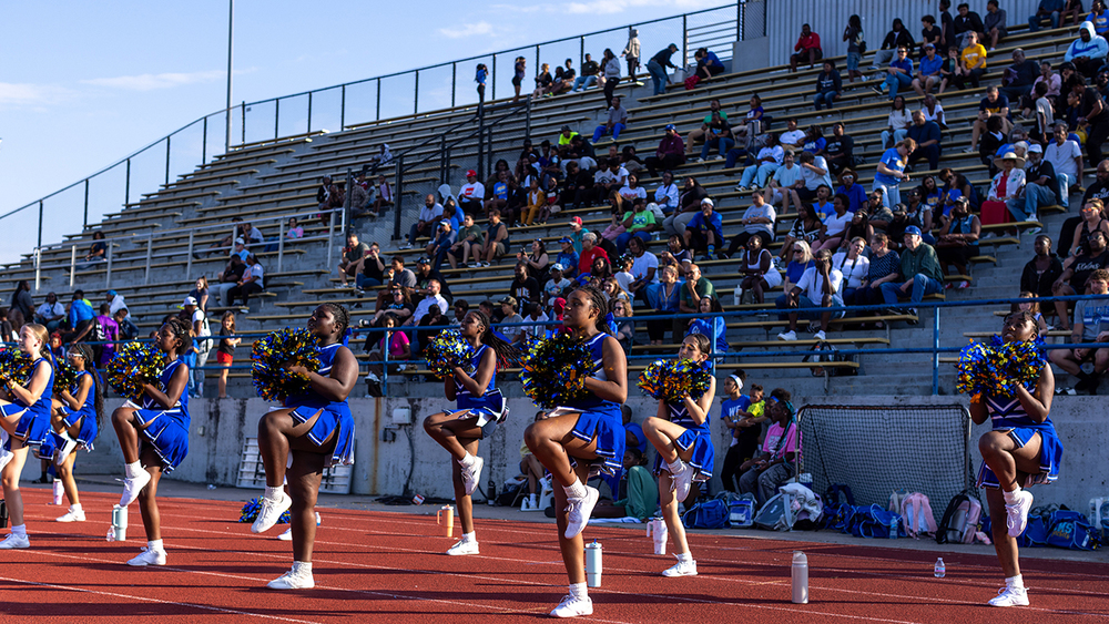 Center Middle School Cheerleaders  cheer in front of a crowd on the CHS track at a fall football game.