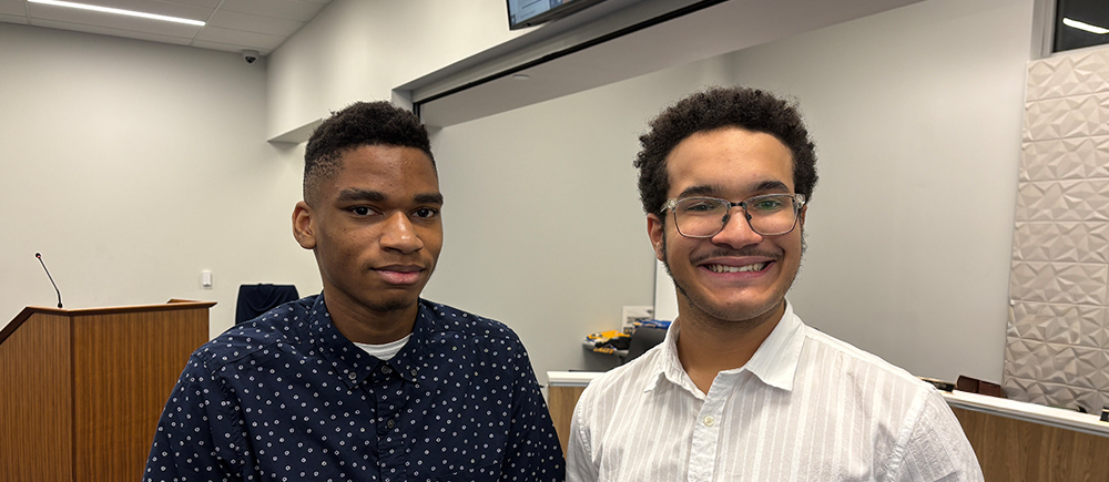 Two young men in collared shirts smile .
