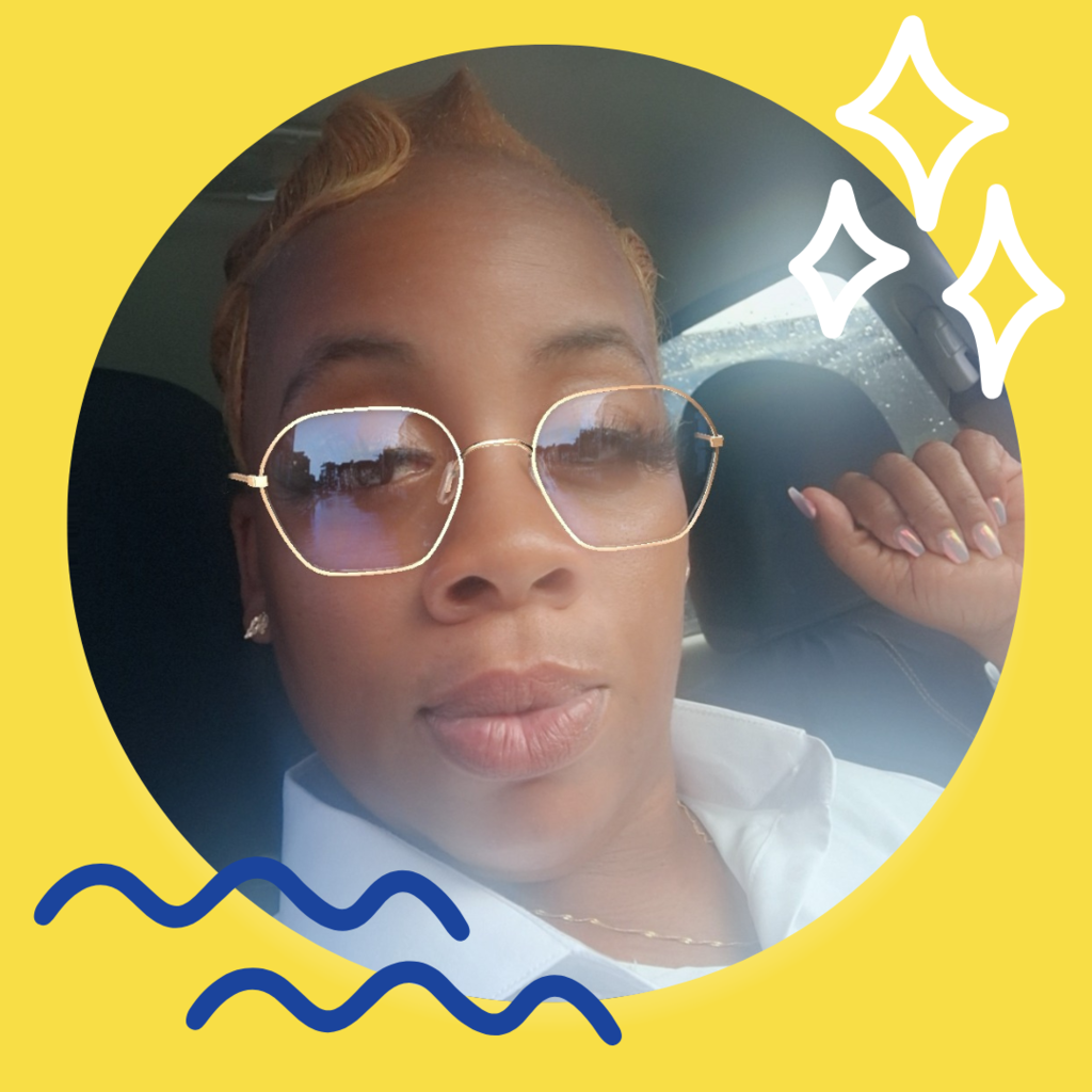 Woman in gold frame glasses and white collar shirt poses for a selfie.